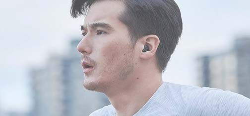 Hörgerät in einem Ohr eines jungen Mannes