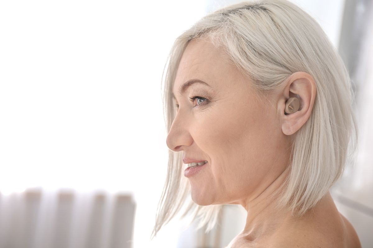 Frau mit Hörgerät im Ohr